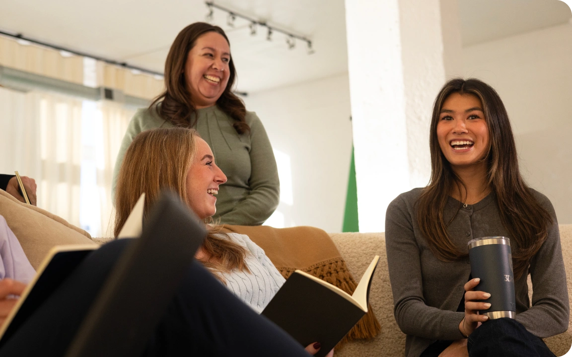Team members laughing together in a bright meeting space