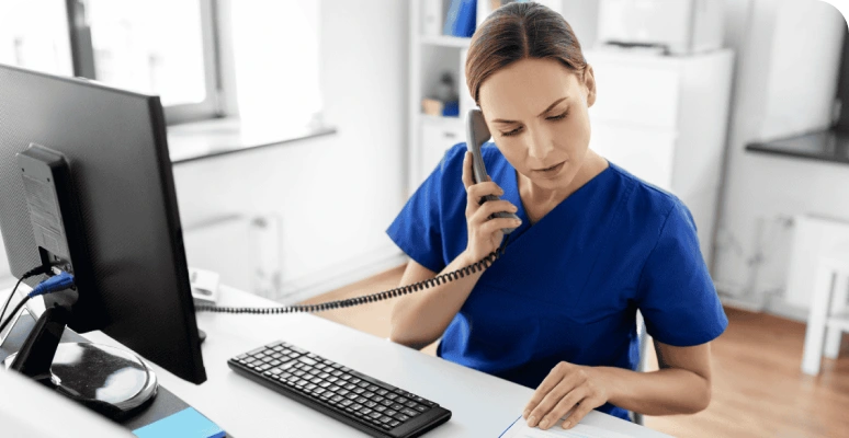 A clinician speaking with a patient at a desk
