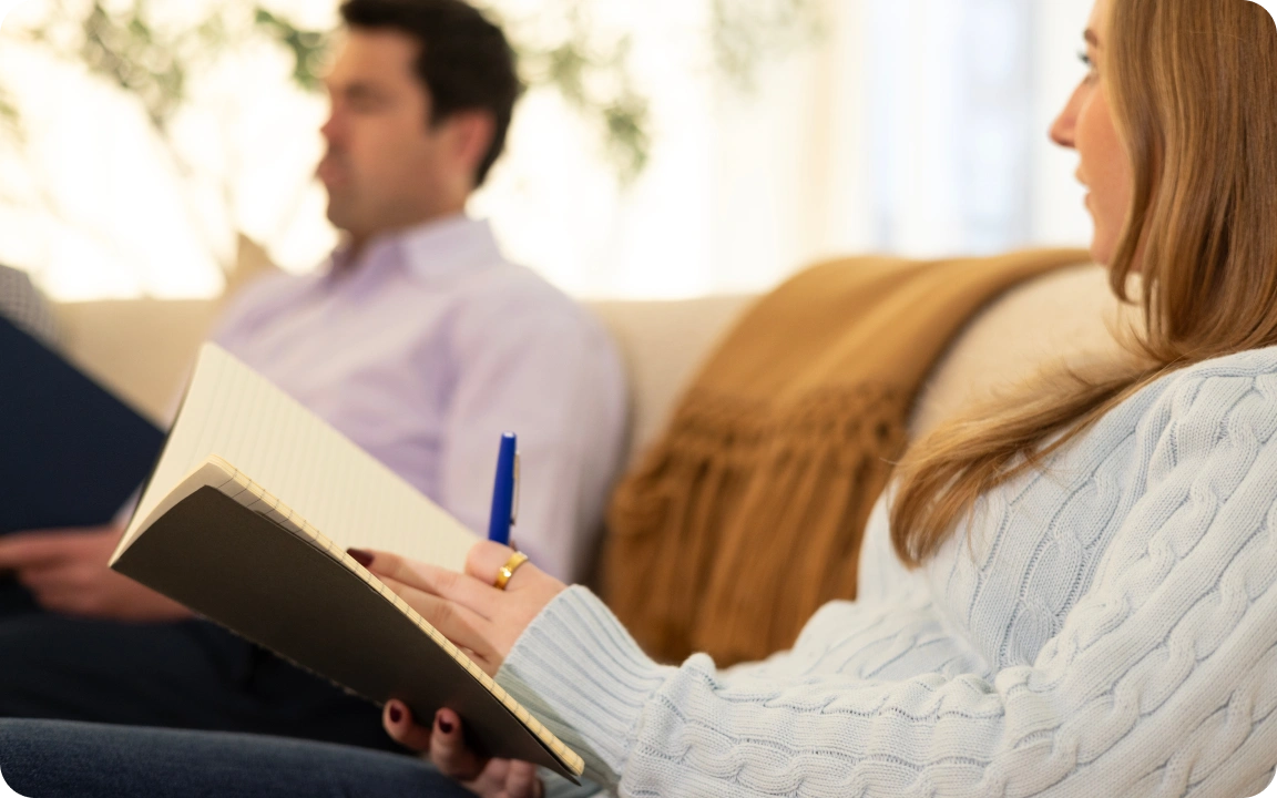 Two colleagues reviewing a printed report on a sofa